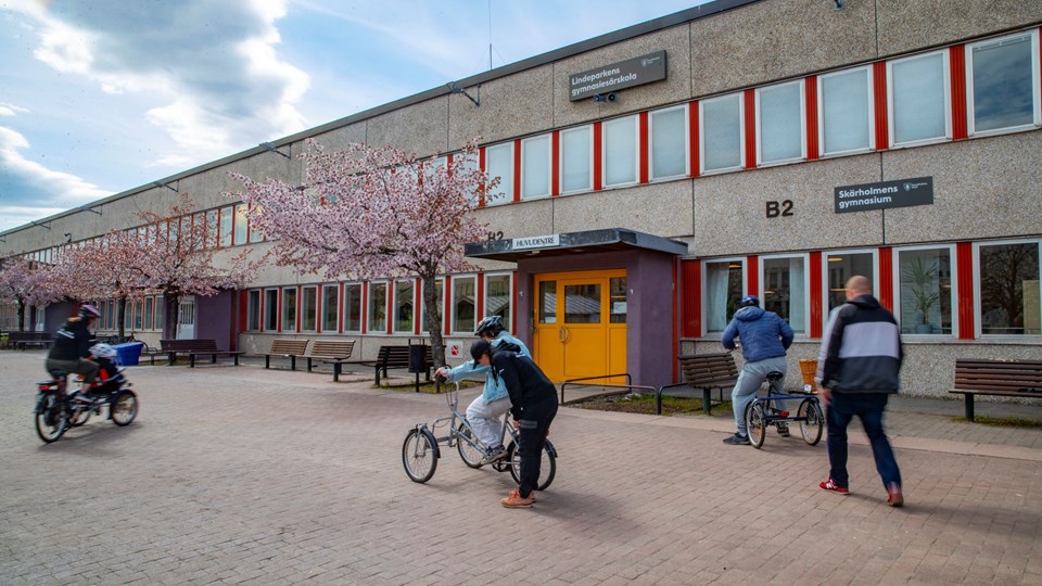 Elev cyklar framför portal på skolgården