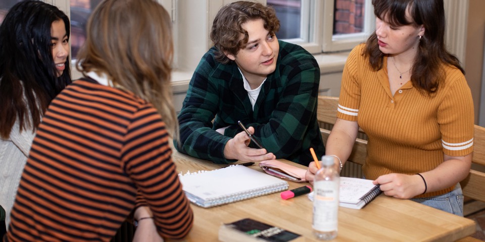 Elever samtalar med varandra vid ett bord.