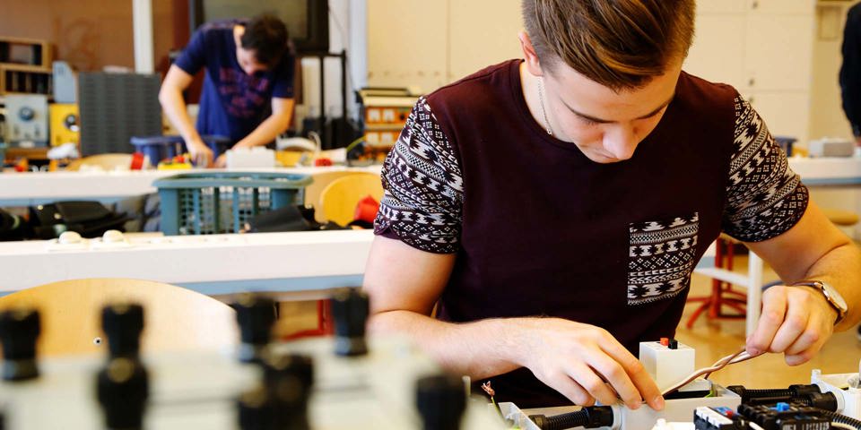 Elev som arbetar vid skolbänk med el