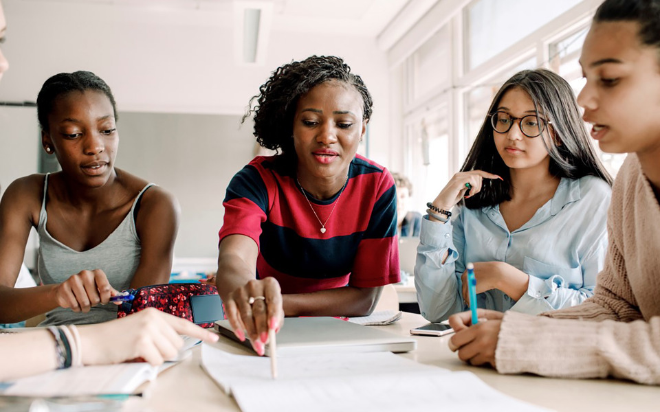 Elever tittar i papper och pekar med penna.