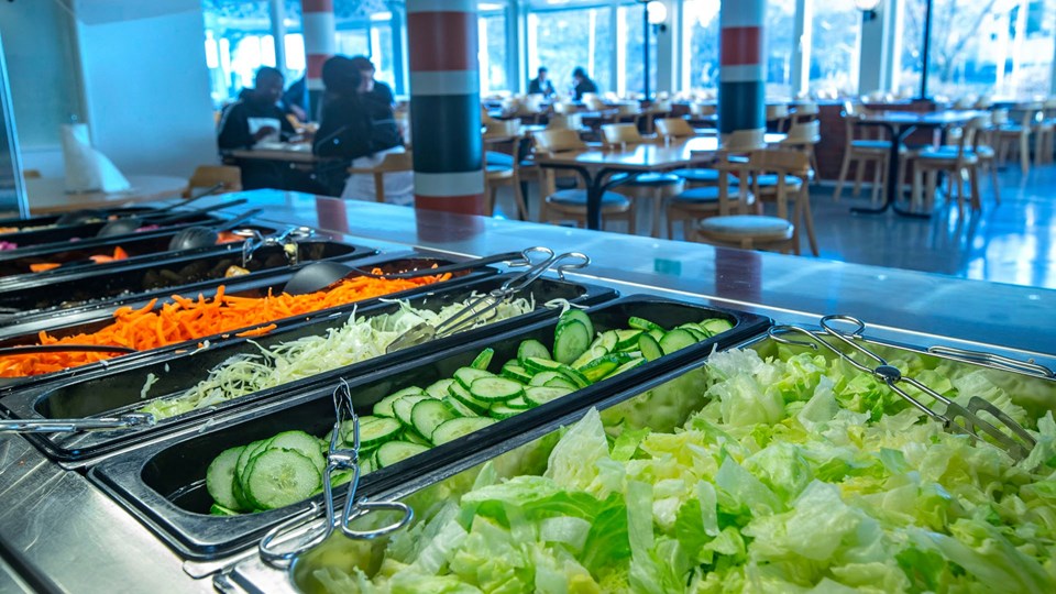 Tråg med olika grönsaker serveras i en matsal.