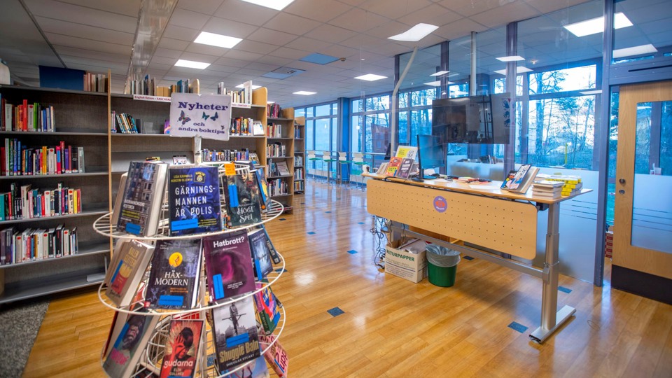 Interiörbild från biblioteket med många hyllor med böcker.